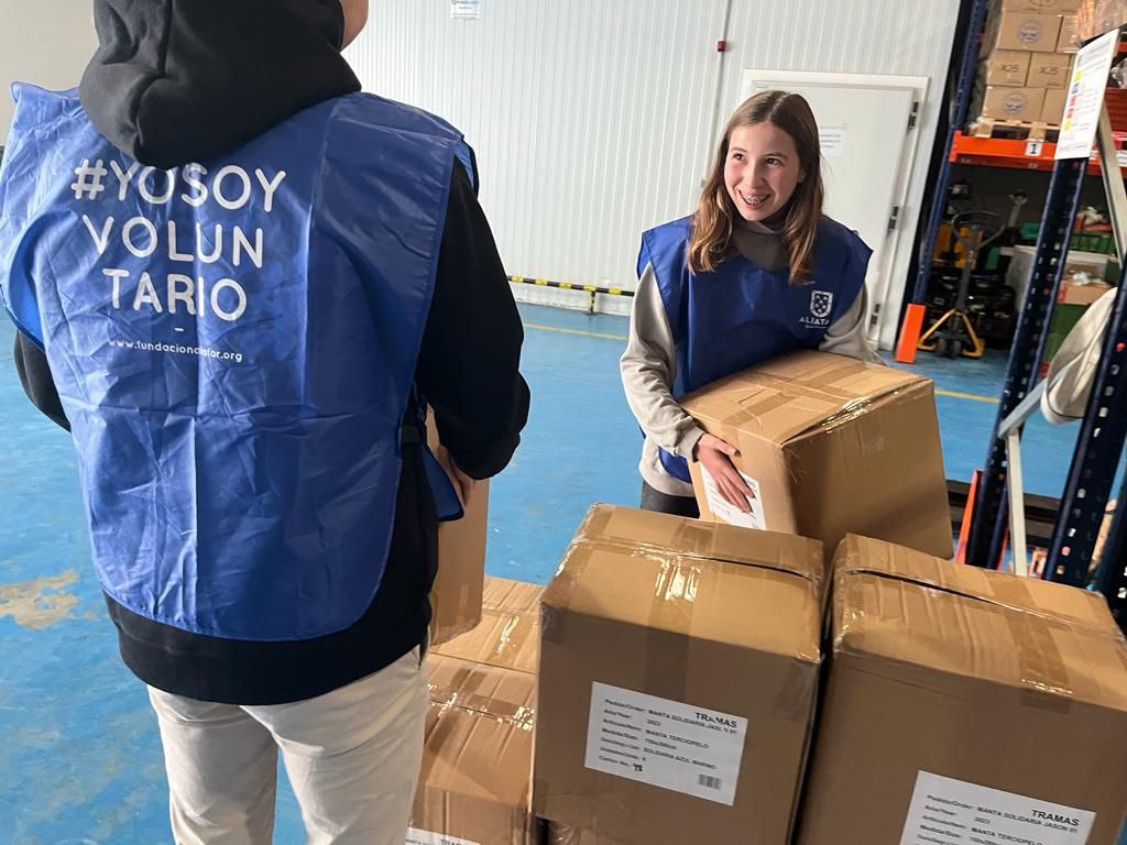 Voluntarios recogiendo en el Banco de Alimentos de Jaén unas mantas donadas por Tramas.